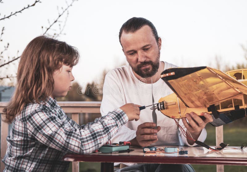 De zoon en het vader gemaakte eigengemaakte radio-gecontroleerde modelvliegtuigenvliegtuig zijn hand - gemaakt niet auteursrecht royalty-vrije stock fotografie De zoon en het vader gemaakte eigengemaakte radio-gecontroleerde modelvliegtuigenvliegtuig zijn hand - gemaakt niet auteursrecht royalty-vrije stock fotografie