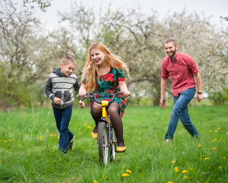 De zoon van het moederonderwijs om een fiets door zijn voorbeeld te berijden royalty-vrije stock afbeeldingen De zoon van het moederonderwijs om een fiets door zijn voorbeeld te berijden royalty-vrije stock afbeeldingen