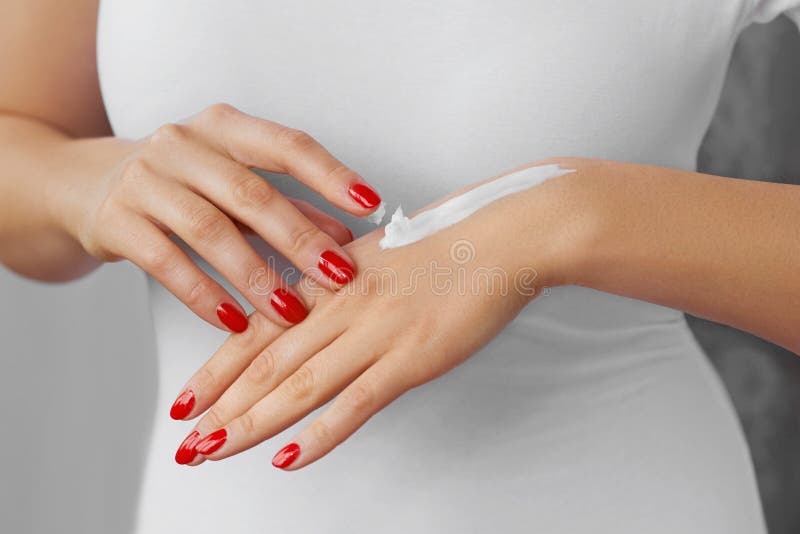 De Zorg van de handhuid Sluit omhoog van vrouwelijke handen toepassend room, lotion Mooie vrouwenhanden met rode manicure Spijker royalty-vrije stock afbeeldingen De Zorg van de handhuid Sluit omhoog van vrouwelijke handen toepassend room, lotion Mooie vrouwenhanden met rode manicure Spijker royalty-vrije stock afbeeldingen