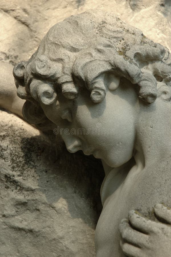 Statue in silent grief leaning against a tombstone. Statue in silent grief leaning against a tombstone