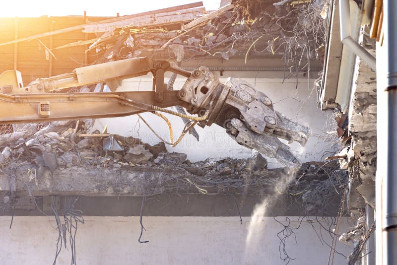 De zware pijl van materiaal hydraulische scharen ontmantelt het gebouw, vernielingsvernietiging Sluit omhoog mening royalty-vrije stock foto De zware pijl van materiaal hydraulische scharen ontmantelt het gebouw, vernielingsvernietiging Sluit omhoog mening royalty-vrije stock foto