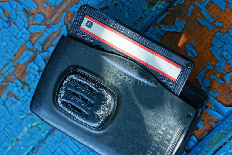 de zwarte audiospeler met een cassette ligt op een versleten blauwe lijst stock afbeelding de zwarte audiospeler met een cassette ligt op een versleten blauwe lijst stock afbeelding