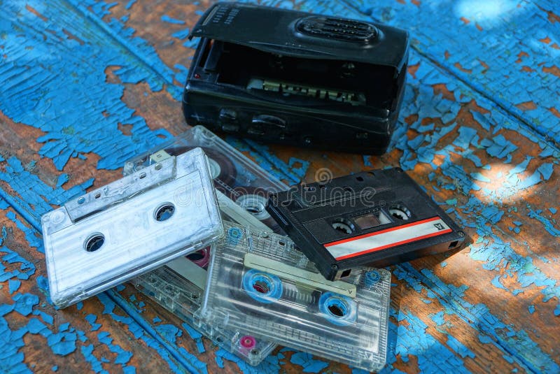 De zwarte audiospeler met een cassette ligt op een versleten blauwe lijst stock foto's De zwarte audiospeler met een cassette ligt op een versleten blauwe lijst stock foto's