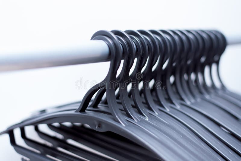 de zwarte plastic hangers hangen op een lichte achtergrond vele verschillende hangers stock afbeelding de zwarte plastic hangers hangen op een lichte achtergrond vele verschillende hangers stock afbeelding