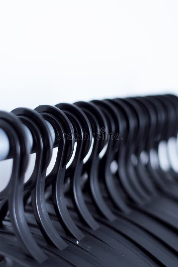 de zwarte plastic hangers hangen op een lichte achtergrond vele verschillende hangers stock foto's de zwarte plastic hangers hangen op een lichte achtergrond vele verschillende hangers stock foto's