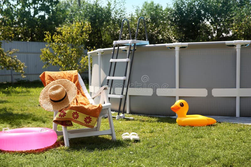 Deasupra bazinului de înot, pliant, prosop de scaun, inele gonflabile și pălărie în curtea din spate royalty free stock photo