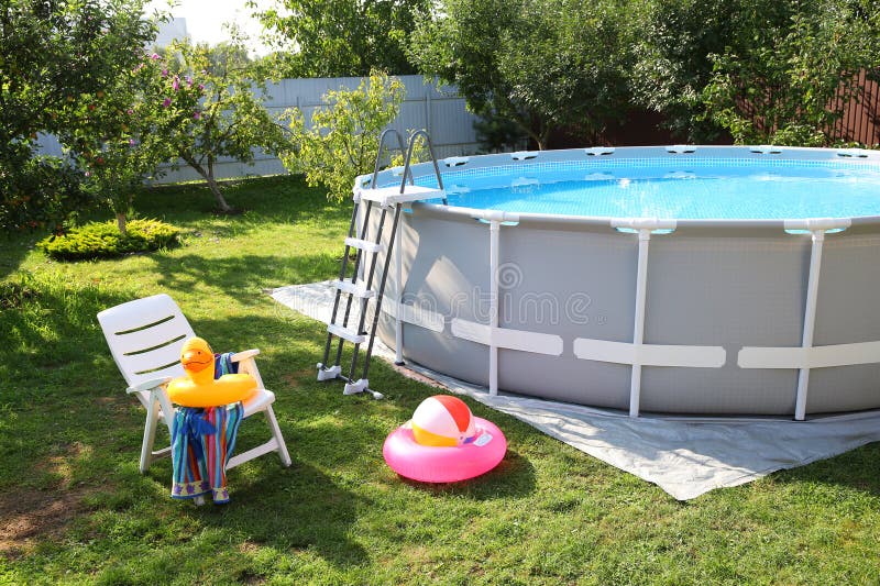 Deasupra solului piscină pliantă scaun prosop inele gonflabile și minge în curte stock photo