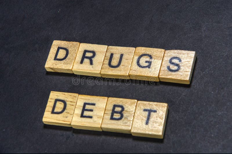 close up photo of the words drug debt on wood squares. close up photo of the words drug debt on wood squares