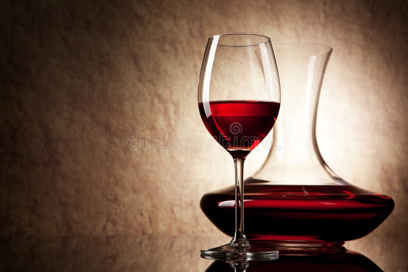 Decanter with red wine and glass on a old stone