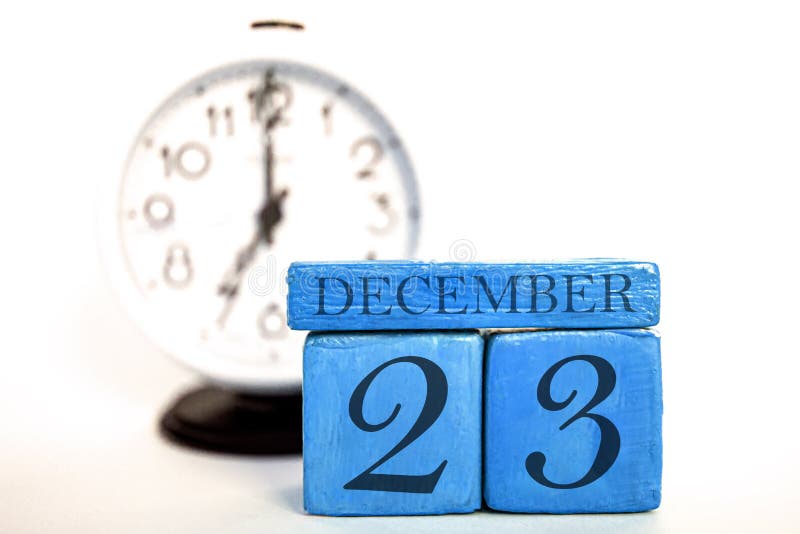 december 23rd. Day 23 of month, handmade wood calendar and alarm clock on  blue color. winter month, day of the year concept