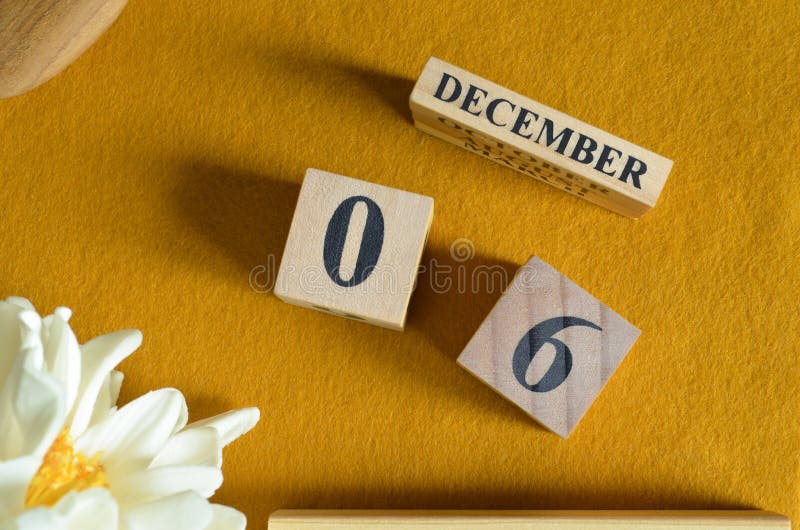 December 06, Wooden Calendar cube with yellow felt fabric with peony flower for date icon background. royalty free stock photos