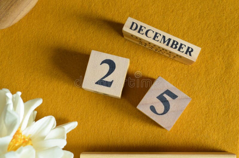 December 25, Wooden Calendar cube with yellow felt fabric with peony flower for date icon background. royalty free stock image