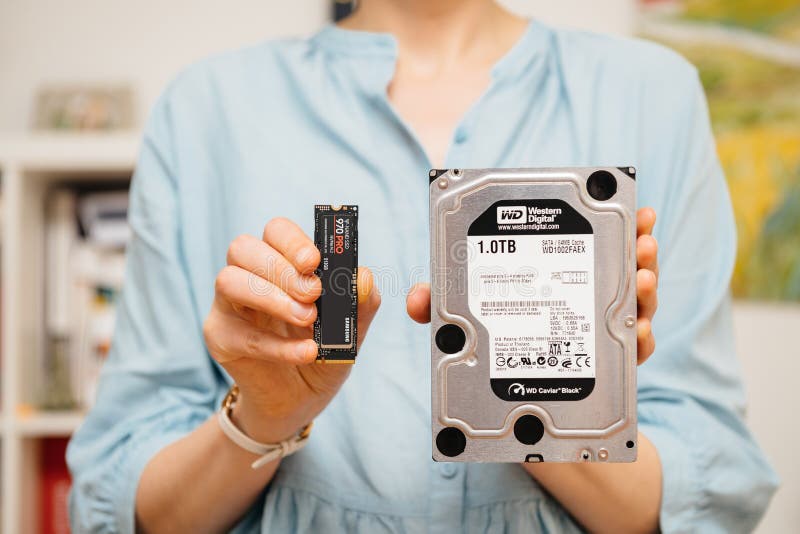 Decisione HDD o NVME della tenuta della donna fotografia stock libera da diritti Decisione HDD o NVME della tenuta della donna fotografia stock libera da diritti