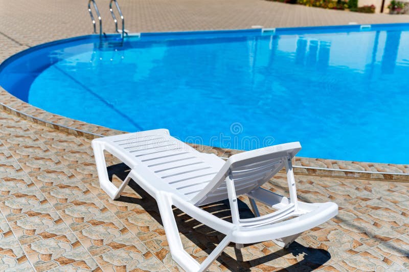 Empty Plastic White Deck Chairs Near the Swimming Pool Stock Image