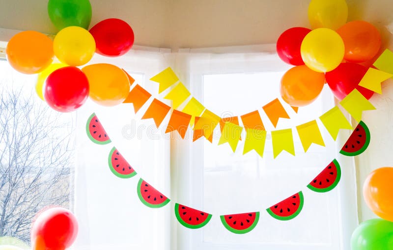 Decor for a holiday of children`s birthday. Fruit party. Cake and sweet candy. Disposable tableware and tropical fruits. Watermelon and pineapple costume