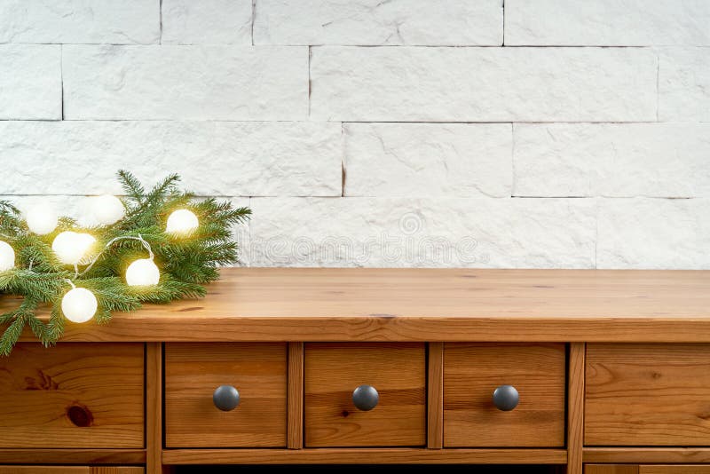 Christmas decoration with twigs of spruce and lightson an old shelf on the background of a white brick wall. Christmas decoration with twigs of spruce and lightson an old shelf on the background of a white brick wall