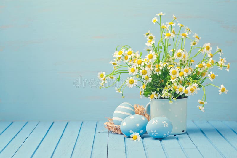 Decoración del día de fiesta de Pascua con las flores de la margarita y los huevos pintados