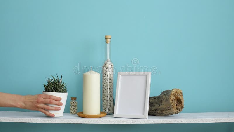 Decoración moderna del sitio con la maqueta del marco Estante blanco contra la pared en colores pastel de la turquesa con la vel