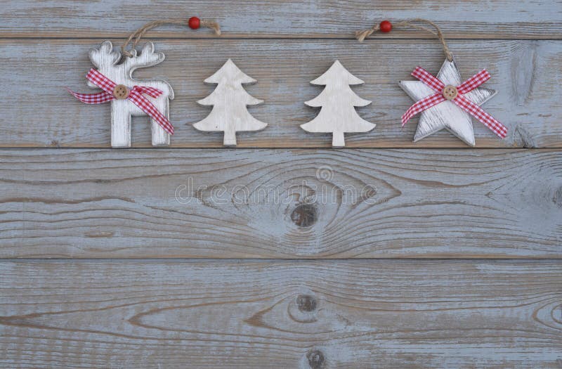 Decoración roja blanca de la Navidad como el árbol de navidad, el reno y estrella en un viejo fondo de madera gris de los tablone imagenes de archivo Decoración roja blanca de la Navidad como el árbol de navidad, el reno y estrella en un viejo fondo de madera gris de los tablone imagenes de archivo