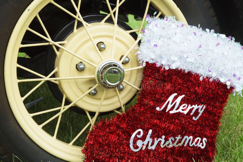 Merry Christmas red stocking decoration and yellow and black car's wheel,green grass,xmas. Merry Christmas red stocking decoration and yellow and black car's wheel,green grass,xmas