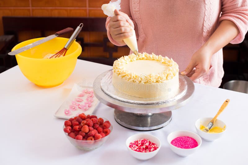 Close-up of woman decorating cake. Close-up of woman decorating cake