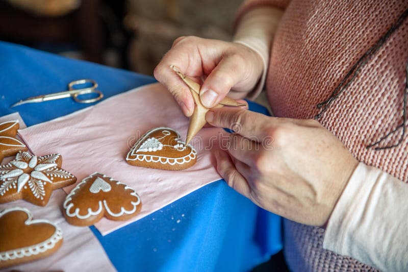 Woman decorate a gingerbread heart. Woman decorate a gingerbread heart