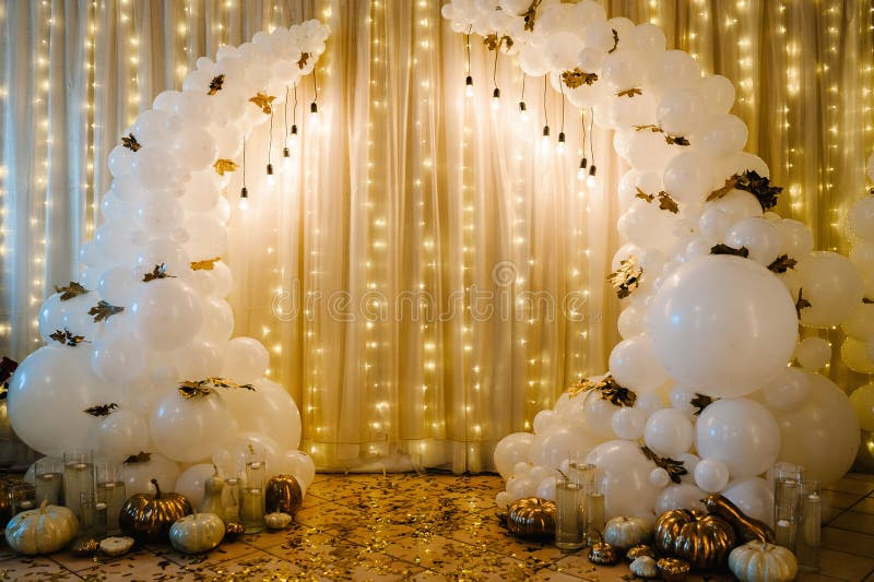 Decorated arch for the wedding ceremony. White balloons, candles, autumn leaves, and small pumpkins. Autumn location and Halloween decor.