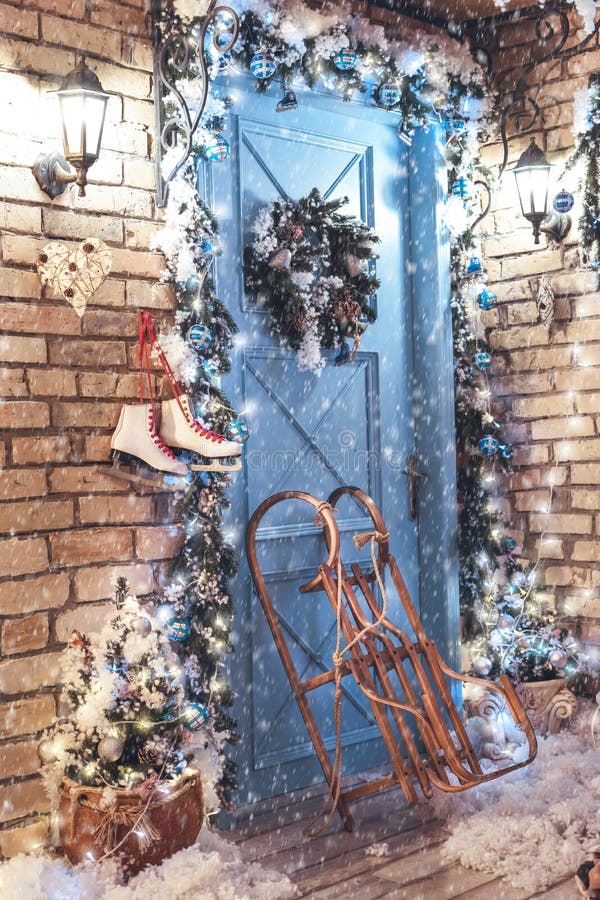 Decorated for Christmas house, blue door, sleigh and ice skates.