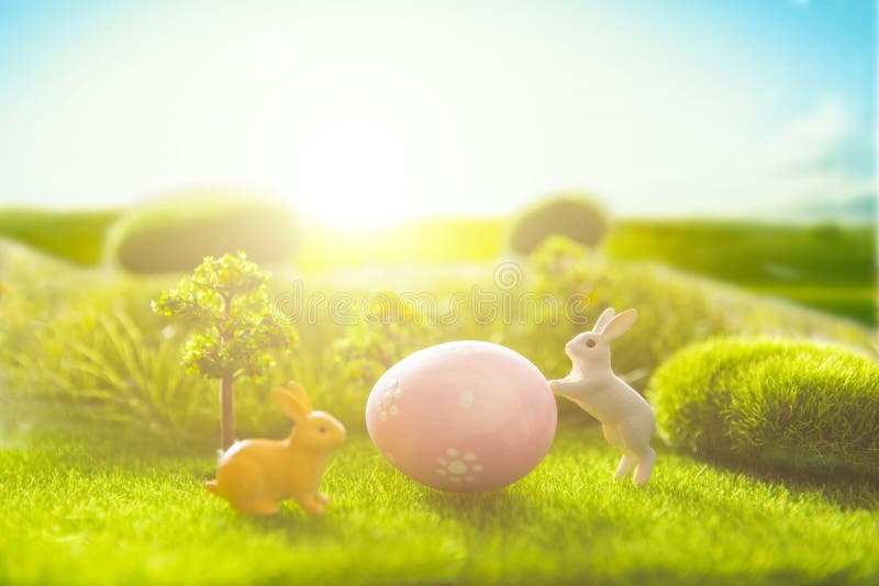 Decorated easter eggs with easter rabbit on grass over sky background stock images