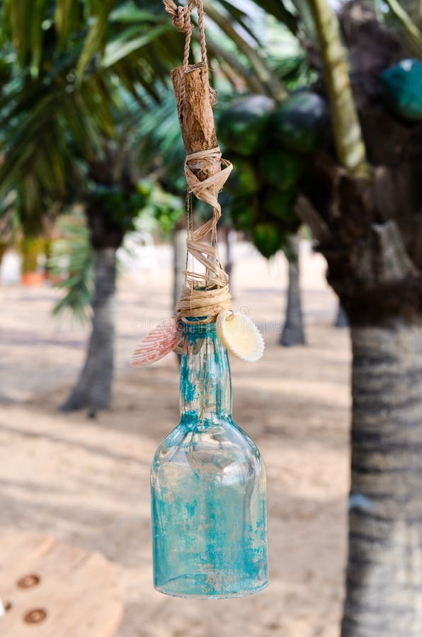 decorated glass bottle on a Tropical beach with palm trees