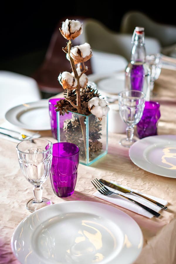 Decorated table ready for dinner. Beautifully decorated table set with flowers, candles, plates and serviettes for wedding or anot