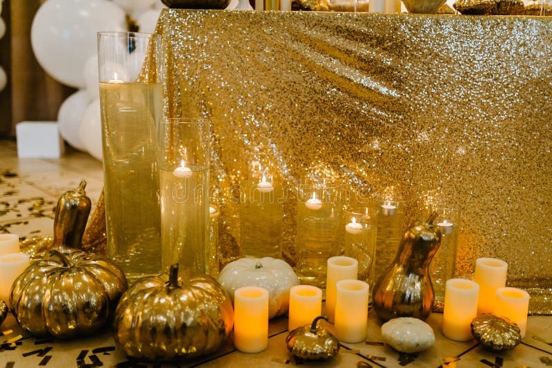 Decorated table for wedding. White balloons, candles, autumn leaves and small pumpkins. Autumn location and Halloween decor. Setting.