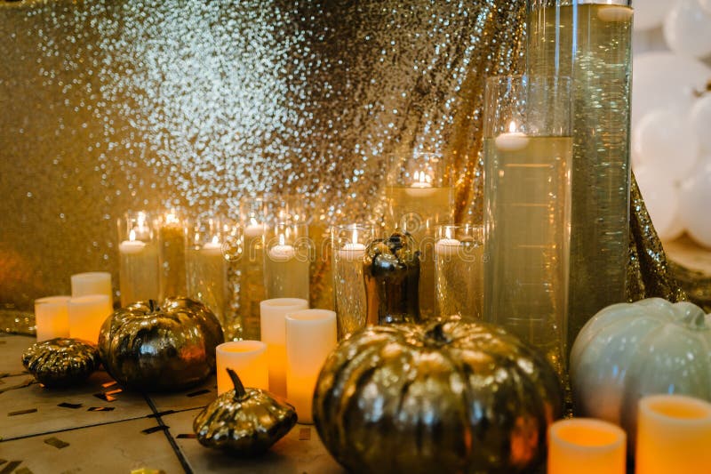 Decorated table for wedding. White balloons, candles, autumn leaves and small pumpkins. Autumn location and Halloween decor. Setting.