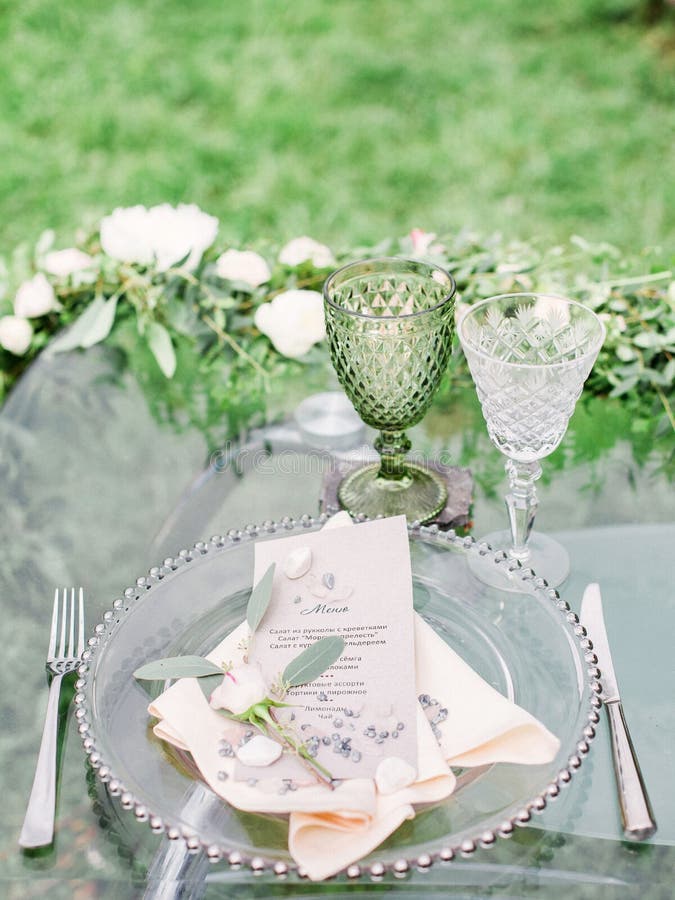 Decorated wedding table with beautiful flower composition, glass for wine and plate, outdoor, fine art.