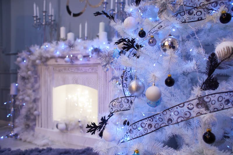 Decorated white Christmas tree in front of the fireplace stock images Decorated white Christmas tree in front of the fireplace stock images