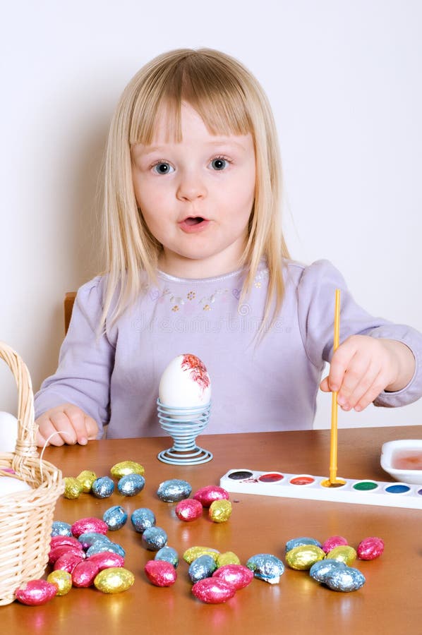 Cute Little Girl Decorating A Basket of Easter Eggs. Cute Little Girl Decorating A Basket of Easter Eggs