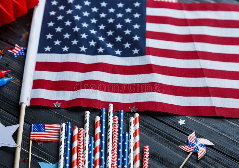 Decorations for 4th of July day of American independence, flag, candles, straws. USA holiday decorations on a wooden background stock images Decorations for 4th of July day of American independence, flag, candles, straws. USA holiday decorations on a wooden background stock images