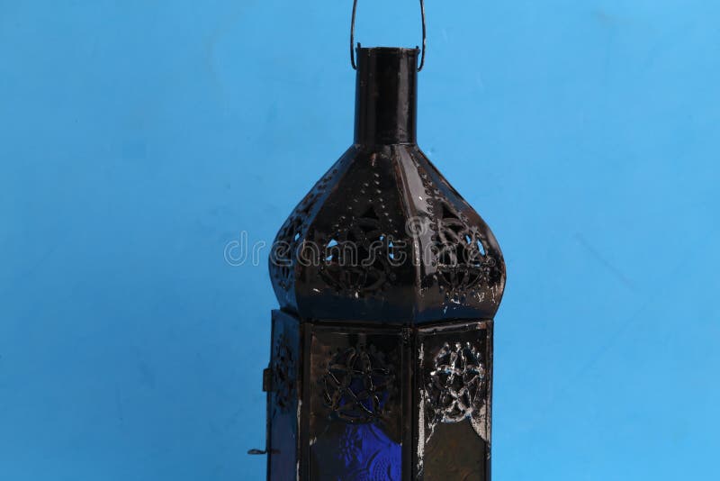 Decorative abstract black lamp on a blue surface stock photography