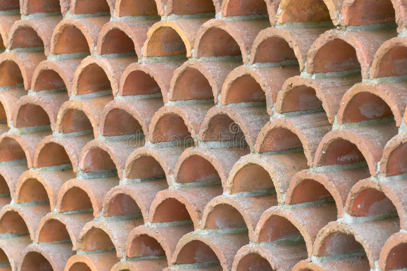 Decorative fence made of semicircular bricks, arranged in a staggered pattern, creating a unique design with gaps between the royalty free stock photos