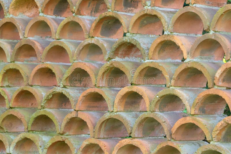 Decorative fence made of semicircular bricks, arranged in a staggered pattern, creating a unique design with gaps between the royalty free stock photography