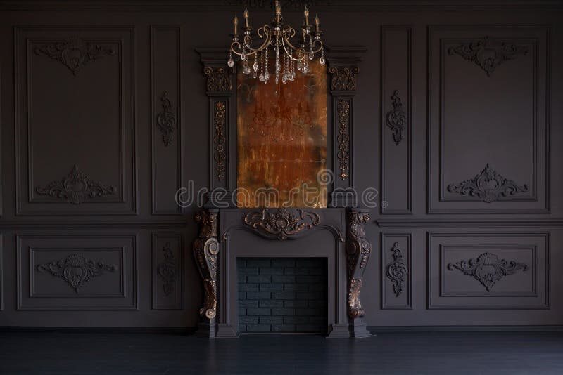 Decorative fireplace, vintage mirror and chandelier in classical black room interior royalty free stock photo