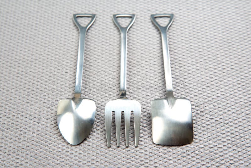 Decorative Fork and Spoons in the Form of Spades on a Gray Background