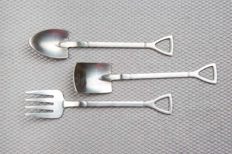 Decorative Fork and Spoons in the Form of Spades on a Gray Background