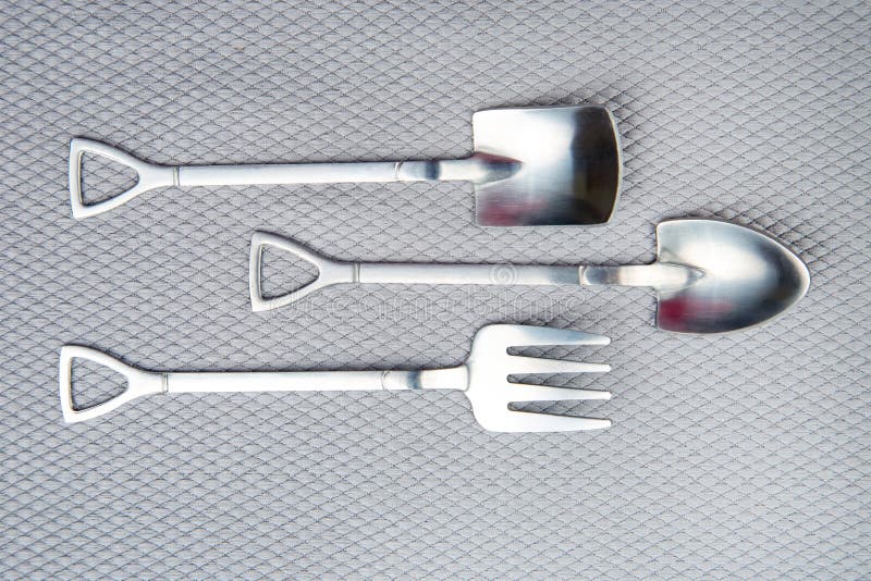 Decorative Fork and Spoons in the Form of Spades on a Gray Background