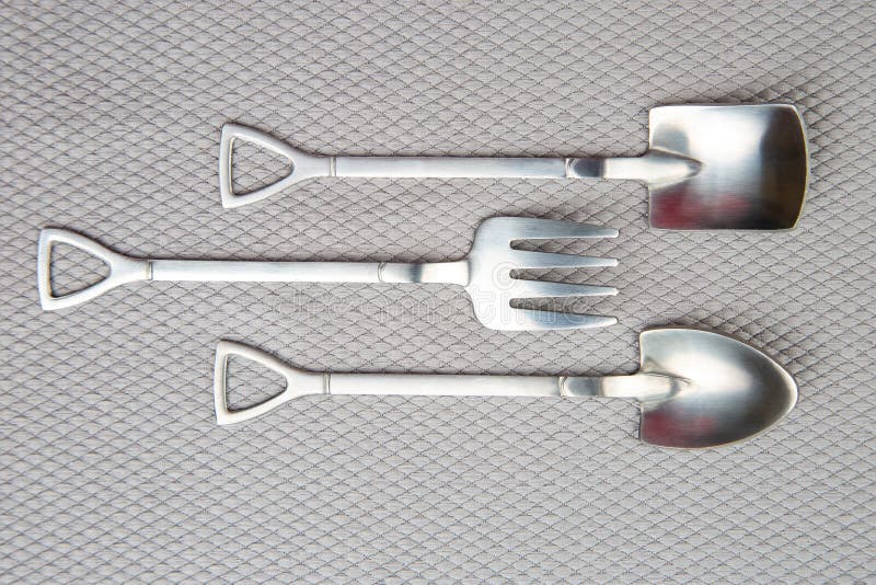 Decorative Fork and Spoons in the Form of Spades on a Gray Background