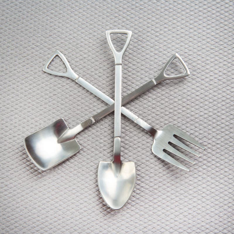 Decorative Fork and Spoons in the Form of Spades on a Gray Background