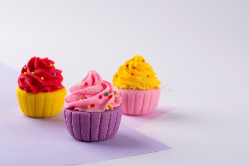 Decorative multicolored sugar cupcakes on light background stock photos