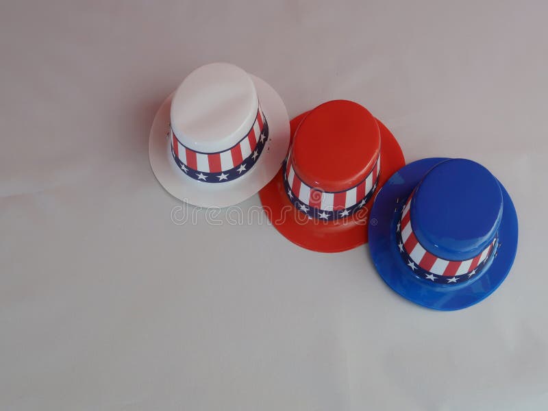 Three decorative party hats in patriotic colors of red, white, and blue colors and hatbands with the Stars and Stripes. Three decorative party hats in patriotic colors of red, white, and blue colors and hatbands with the Stars and Stripes