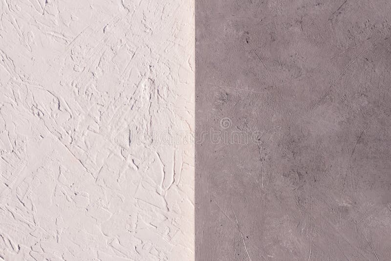 Decorative plaster on the wall is half white and gray surface grainy abstract texture of royalty-vrije stock afbeeldingen