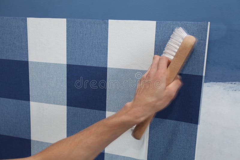 Decorator Hanging Wallpaper with Work Tool in Motion Stock Photo
